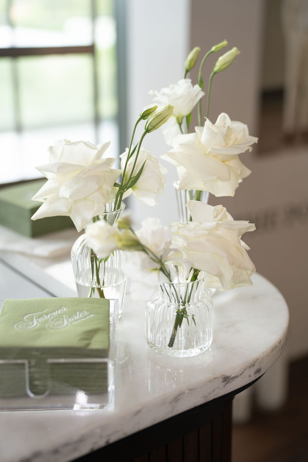 Ivory candles glowing among blush roses and eucalyptus